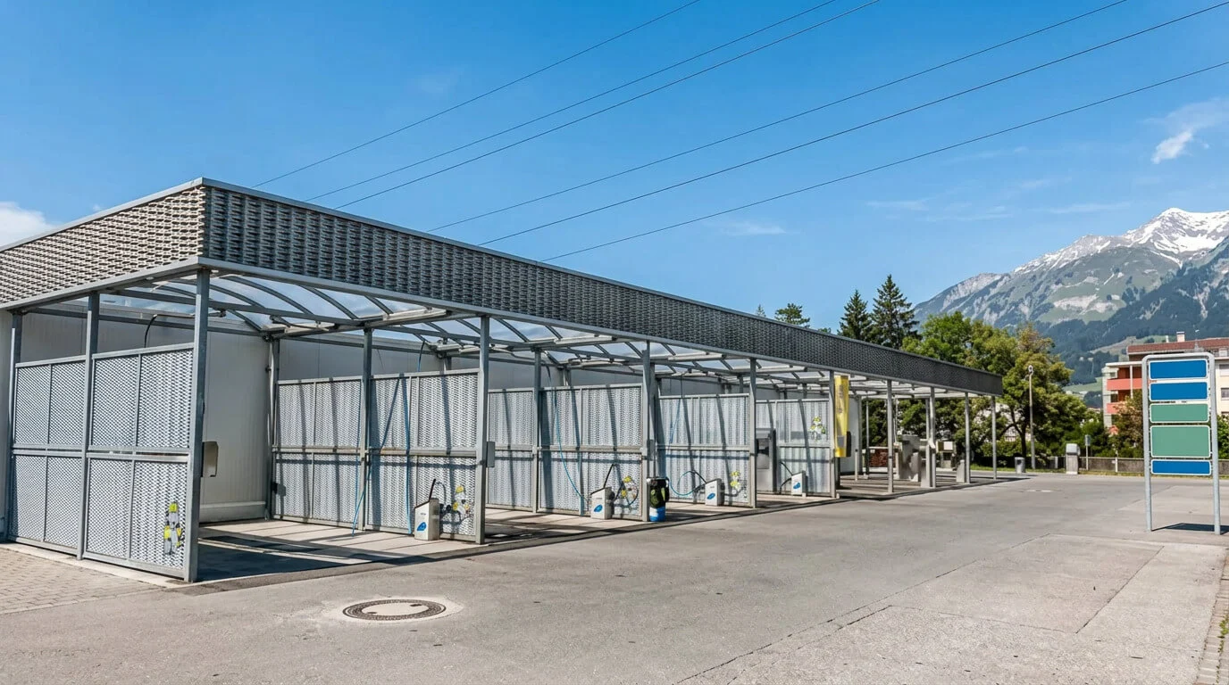 Selbstbedienungs-Autowaschplätze im Freien mit Bergen und Bäumen im Hintergrund. Selbstbedienungs-Autowaschplätze im Freien mit Bergen und Bäumen im Hintergrund.