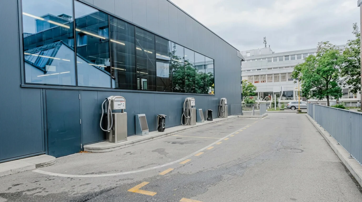 Ladestationen für Elektrofahrzeuge neben einem modernen Gebäude in einer leeren Straße. Ladestationen für Elektrofahrzeuge neben einem modernen Gebäude in einer leeren Straße.